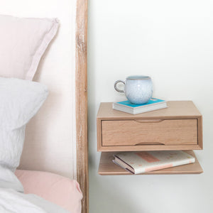 oak floating bedside with blue cup and bed